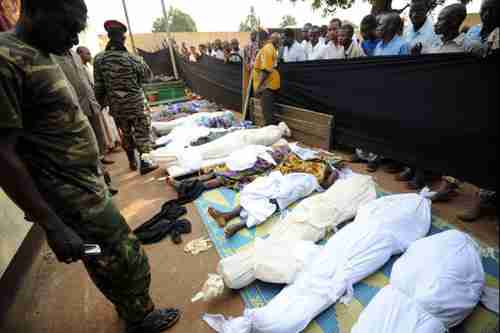 People stand near bodies found lying in a mosque and in its surrounding streets in the Central African capital Bangui on Thursday, after overnight violence (AFP)