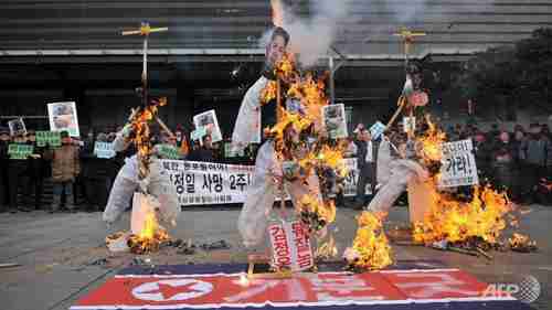 South Koreans burn effigies of North Korean child dictator Kim Jong-un and his late father (AFP)