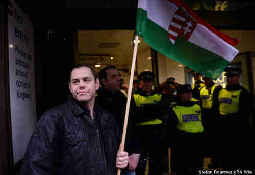 Gabor Vona in London on Sunday, carrying a Hungarian flag, protected from anti-fascist activists by police