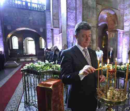 Petro Poroshenko lights a candle in St. Sophia Cathedral after his inauguration in Kiev on Saturday (AP)