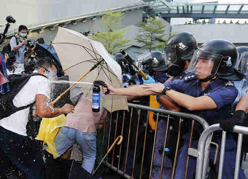 Riot police use pepper spray in Hong Kong on Sunday (Slate)