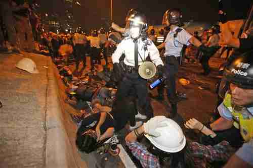 Protesters clash with police officers on the main road outside government headquarters in Hong Kong on Sunday (AP)