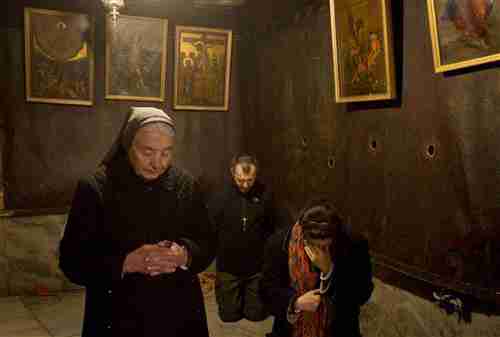Christian pilgrims pray inside the Grotto of the Church of the Nativity, thought to be the birthplace of Jesus Christ, in Bethlehem on Wednesday. (AP)