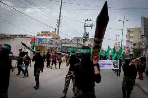 Masked Hamas members carry a model of a rocket in a Gaza rally in December (Flash90)