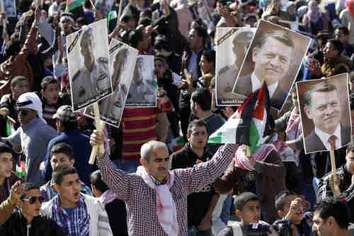 Jordanians chant slogans to show support for government action against ISIS, carrying posters of the slain pilot and of King Abdullah II (AP)