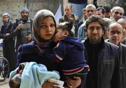 Yarmouk residents queue up to receive humanitarian aid (Reuters)
