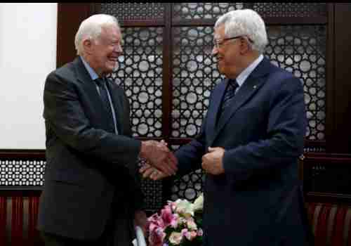 Jimmy Carter shakes hands with Palestinian president Mahmoud Abbas in Ramallah, the West Bank, on Saturday (Reuters)