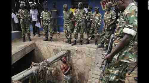 A Hutu youth who escaped a Tutsi mob by hiding in the sewer on Thursday begs for mercy from Burundi soldiers (CNN)
