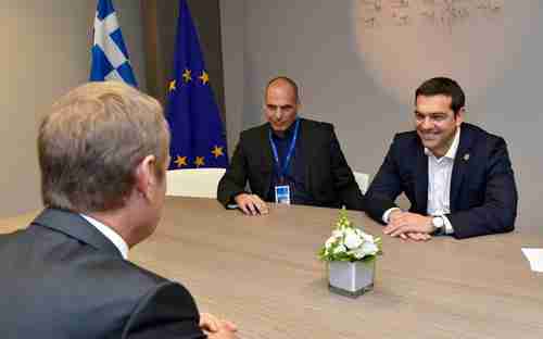 The wily Greek finance minister Yanis Varoufakis watches as Greek PM Alexis Tsipras grins broadly at something amusing said by European Commission president Donald Tusk (Kathimerini)
