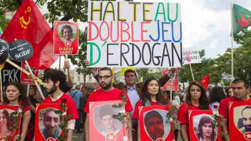 Protesters in Paris carrying a banner saying, 'Stop Erdogan's double game' (AP)