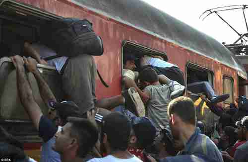 Migrants in Gevgelija Macedonia railway station desperately try to get onto train to Serbia (EPA)