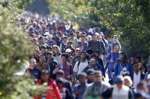 Migrants walk towards the Austrian border from Hungary on Wednesday.  At least 7,000 people crossed from Hungary into Austria on Wednesday alone.  (Reuters)