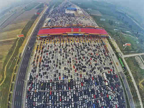 Vehicles stuck in week-long traffic jam on 30-lane highway as they approach a toll booth near Beijing.  (Reuters)