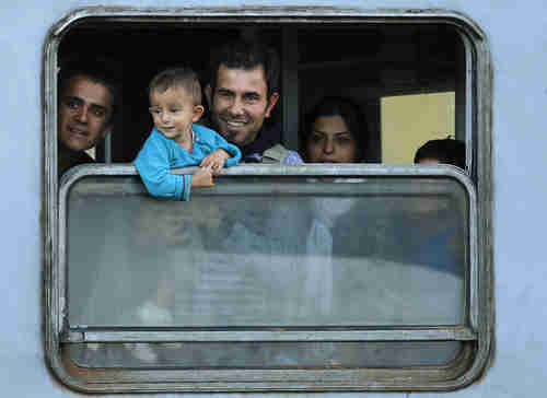 Members of a migrant family look out from a train window at a station in Cakovec, Croatia (Reuters)