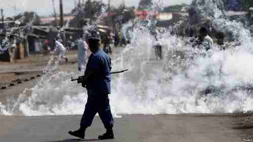 A policeman walks away after throwing a tear gas canister at protesters in Bujumbura (Reuters)