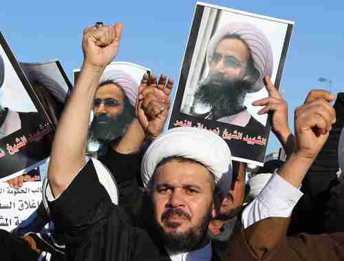 Shia protesters against Saudi Arabia holding posters showing Nimr al-Nimr in Najaf, Iraq, 100 miles south of Baghdad (AP)