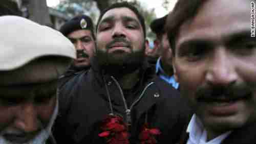 Salman Taseer's murderer, Mumtaz Qadri, arrives in court in 2011, where he's showered with rose petals (AP)