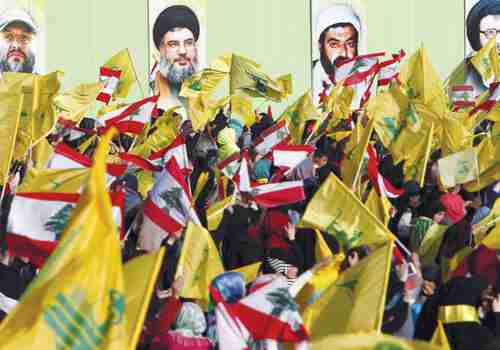 Hezbollah supporters in south Lebanon carry Hezbollah and Lebanese flags (Reuters)