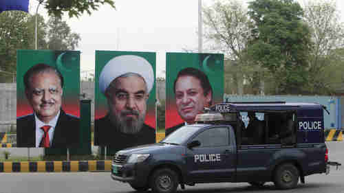 Posters with portraits of Iran's president Hassan Rouhani in the center, with Pakistan's prime minister Nawaz Sharif on the right, and Pakistan's president Mamnoon Hussain on the left, Islamabad on Friday (Reuters)