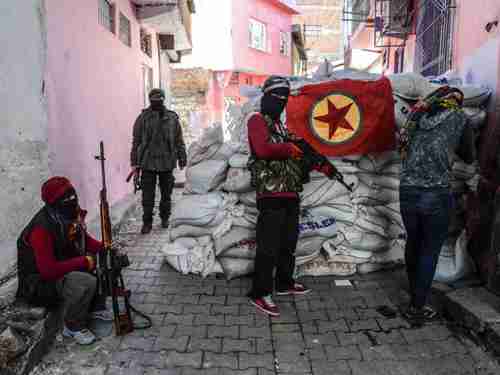 The PKK flag hangs as armed PKK militants man a barricade in southeastern Turkey on November 15 2015 (AFP)