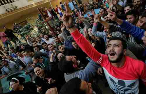 Egyptian Christians shout slogans in front of riot police outside a Cairo church on Monday (Reuters)