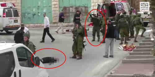 Screen grab from video of March 4, 2016. Israeli soldier reloads his gun just before shooting dead the Palestinian lying wounded and bleeding (AP)