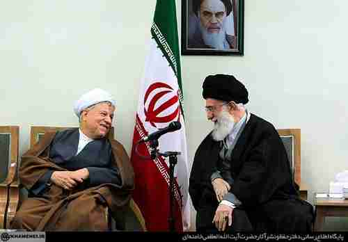 Hashemi Rafsanjani (L) shares a laugh with Supreme Leader Ali Khamenei, under a photo of the original Supreme Leader, Rouhollah Khomeini. All three fought together in the 1979 revolution.