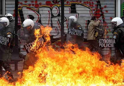 Protesters with riot police in Athens on Friday (EPA)